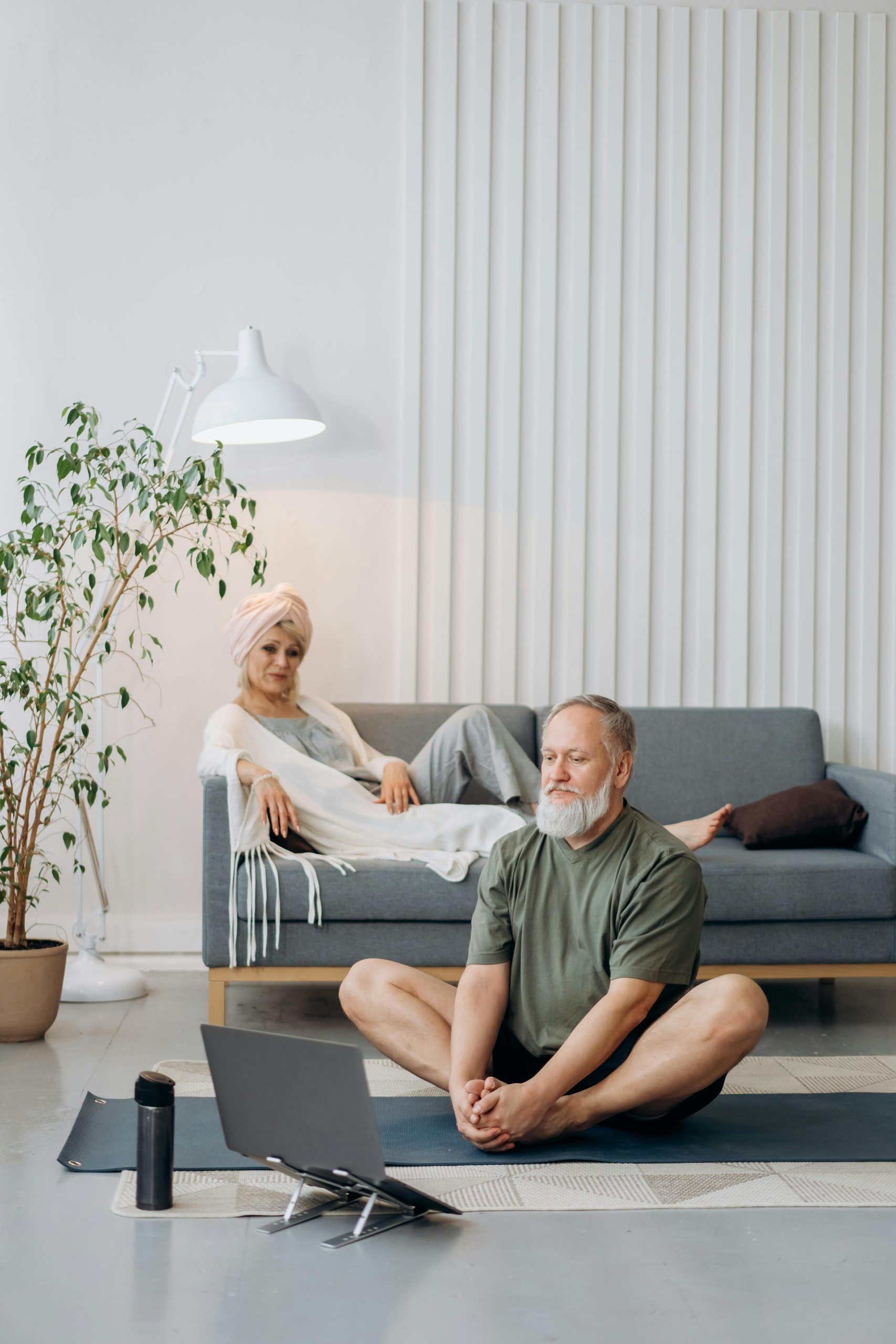 Couple de retraités se détendant dans leur salon en regardant un cours de yoga